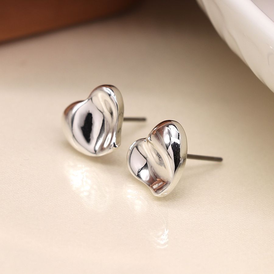 Silver plated wavy heart earrings by POM Jewellery featuring a stylish heart-shaped design with a shiny silver finish.