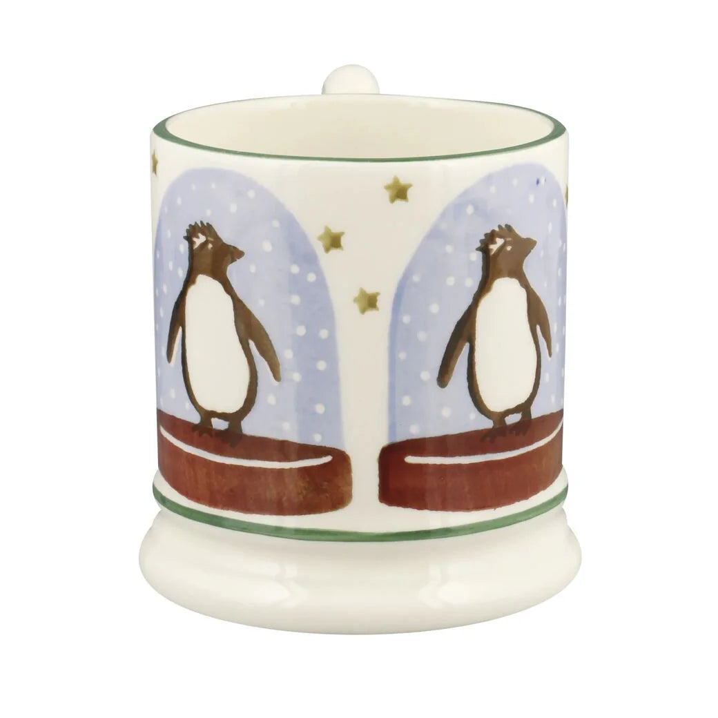 Emma Bridgewater Penguin Snow Globe Half Pint Mug featuring a festive winter scene with cheerful penguins and snowflakes.