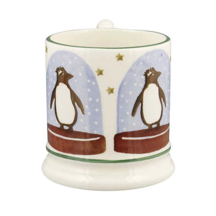 Emma Bridgewater Penguin Snow Globe Half Pint Mug featuring a festive winter scene with cheerful penguins and snowflakes.