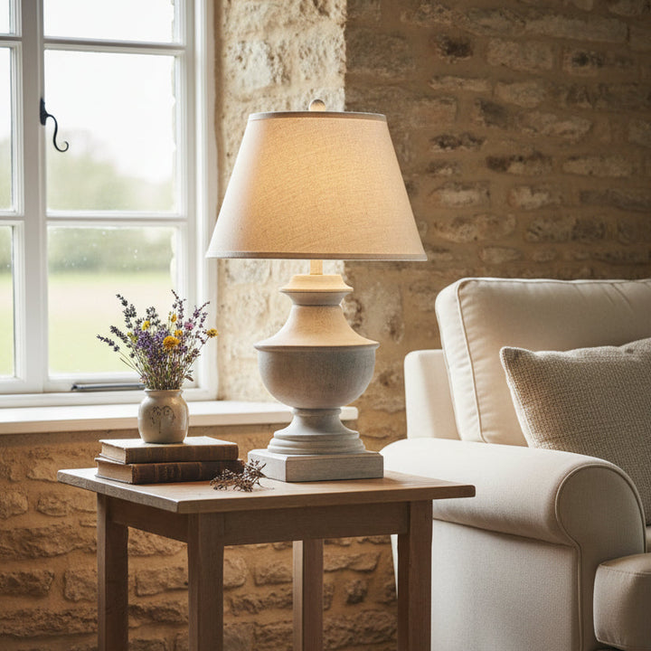Table lamp with a beige shade and textured base on a white background