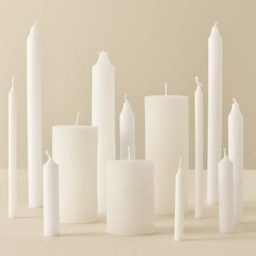 White rustic short dinner candle by IB Laursen, shown in a natural setting with a textured surface and warm ambient lighting.