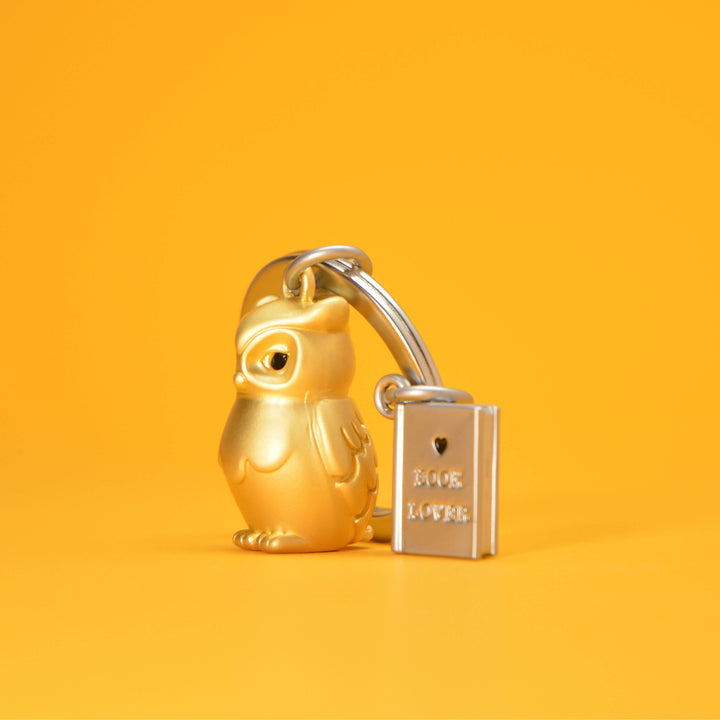 Gold owl and book keyring by Oli Olsen featuring a detailed owl figure and a miniature book charm on a keyring.