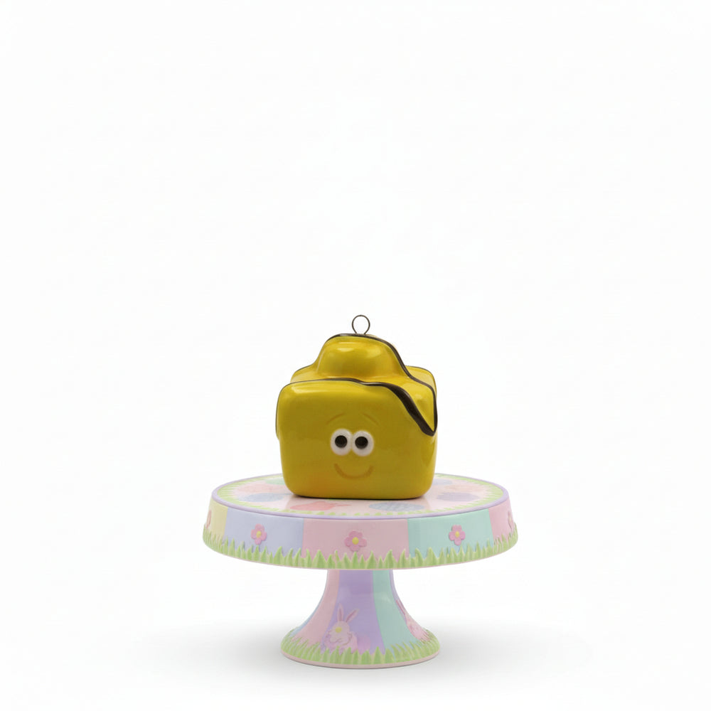 Yellow cube-shaped birdhouse with a smiley face on a white background