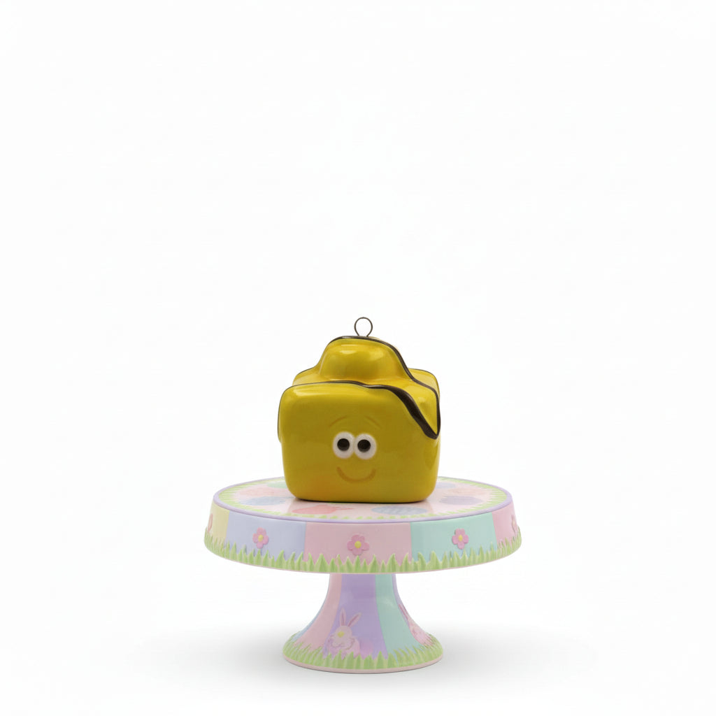 Yellow cube-shaped birdhouse with a smiley face on a white background