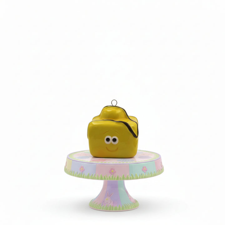 Yellow cube-shaped birdhouse with a smiley face on a white background