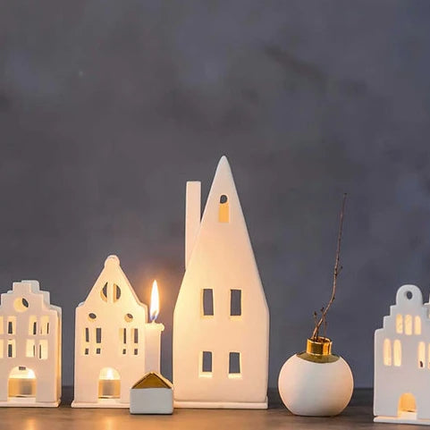 Radër pitched roof tea light house by Cornucopia Home and Gift with detailed wooden design and small window openings.