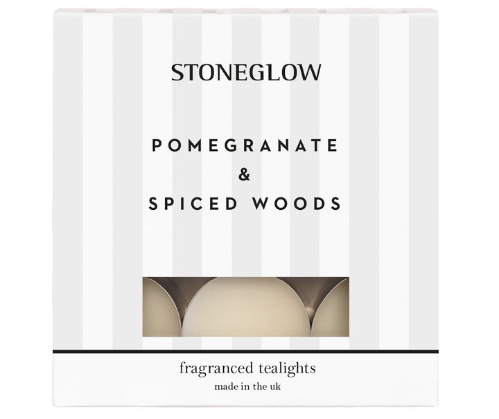 Stoneglow Pomegranate &amp; Spiced Woods scented tealights in a clear glass holder, with a warm, inviting glow and aromatic scent.