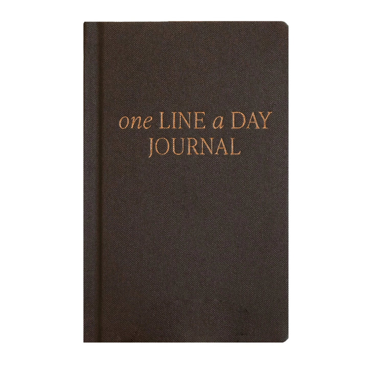 A dark brown hardcover journal with gold foil text reading &