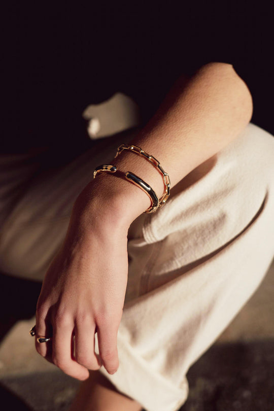 Gold Dew Bangle by Tutti &amp; Co, featuring a delicate, shimmering gold design displayed on a neutral background.