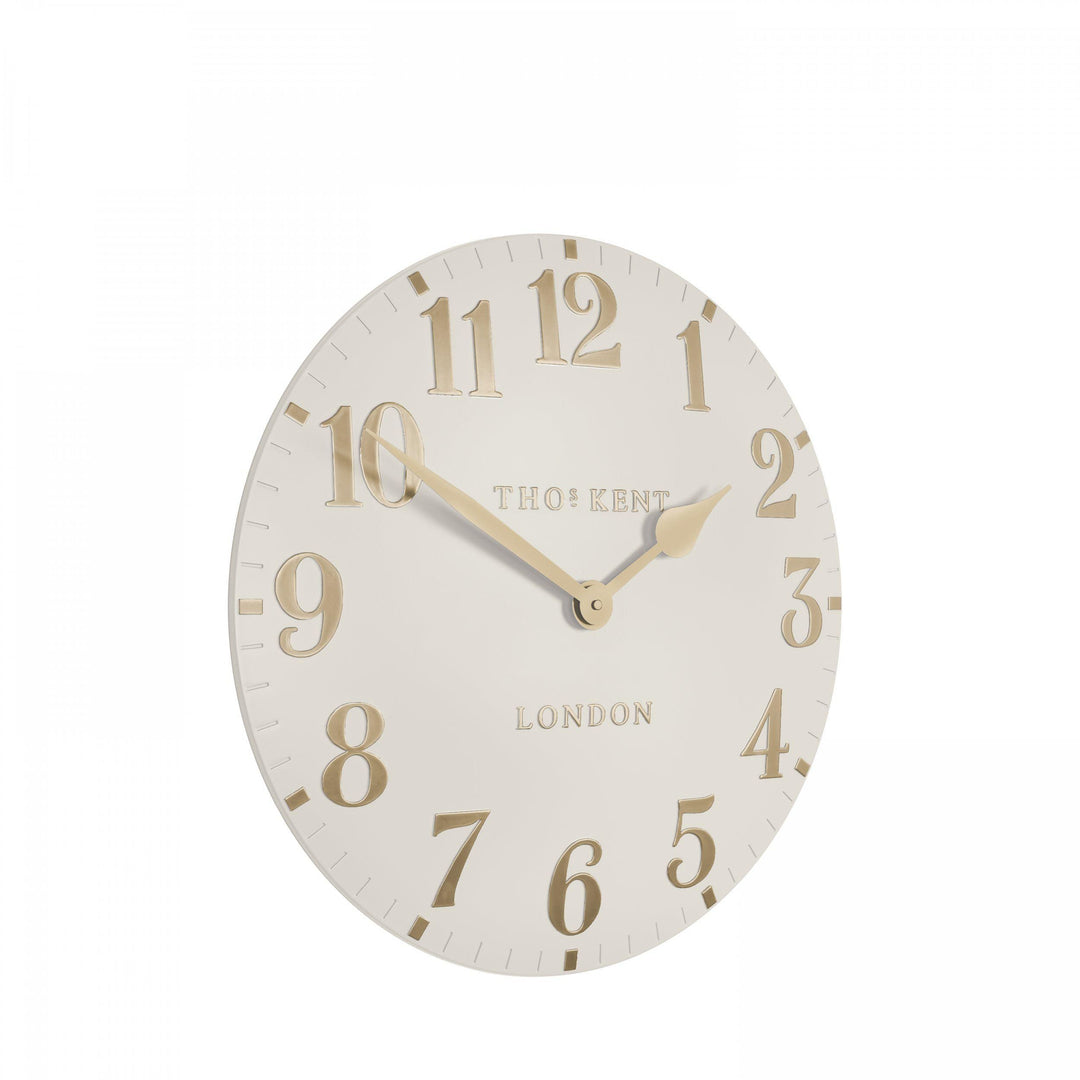 12-inch Arabic wall clock in oatmeal color by Cornucopia Home and Gift, featuring stylish Arabic numerals on a modern clock face.