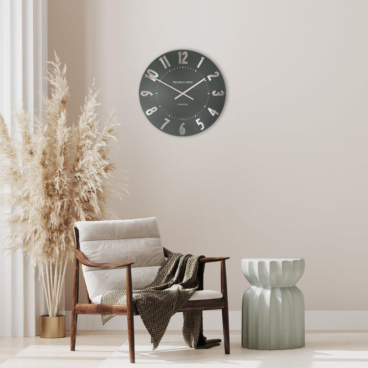 Olive green 20-inch Arabic wall clock by Cornucopia Home and Gift, featuring bold black Arabic numerals and sleek design.