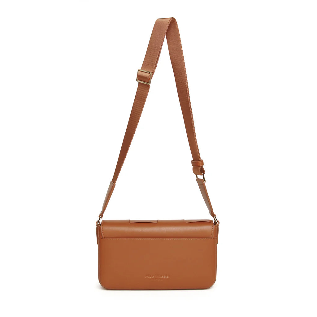 Tan Lisbon Cross Body Bag by Alice Wheeler, featuring a sleek design and adjustable strap, shown from a side view.