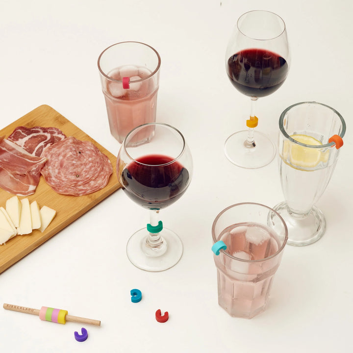 Colorful rainbow drink markers by Kikkerland for labeling wine glasses, featuring vibrant rainbow designs.