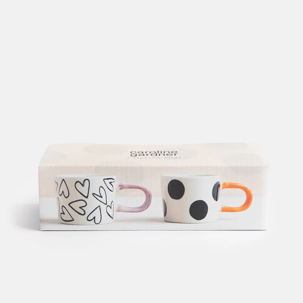 Two Caroline Gardner mono spot and hearts espresso cups from the gift set, featuring stylish designs on elegant ceramic.