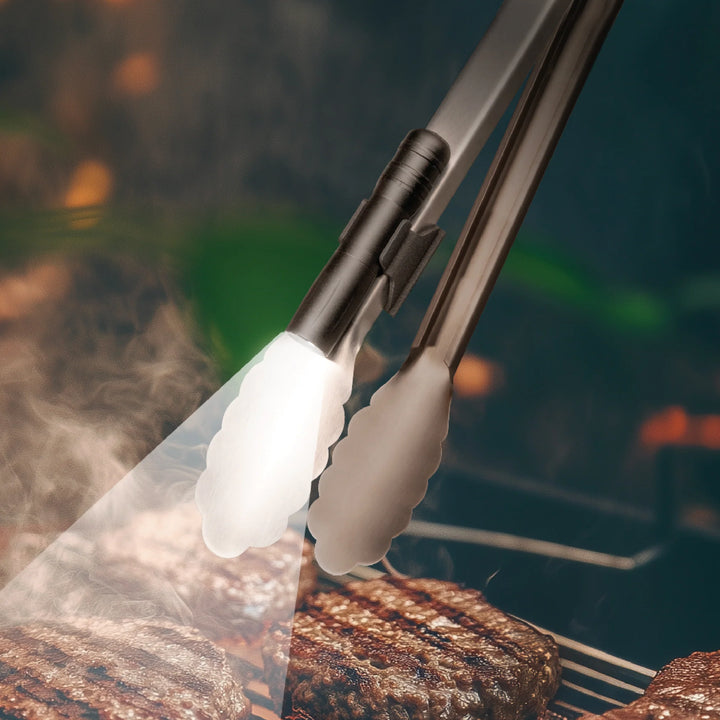Kikkerland BBQ clamp light attached to a grill, providing focused illumination for outdoor cooking and grilling activities.