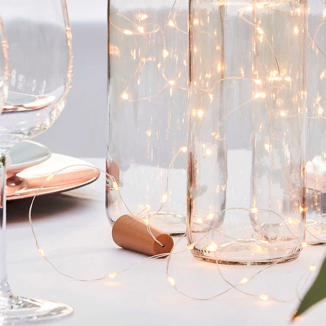 Ginger Ray Botanical Wedding cork bottle lights with greenery and floral decorations, ideal for wedding decor.