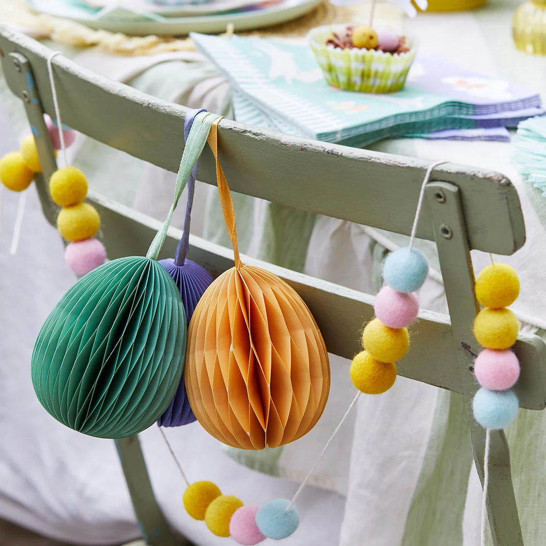 Set of three hanging honeycomb egg decorations with felt bunny garland for Easter party decor by Cornucopia Home and Gift