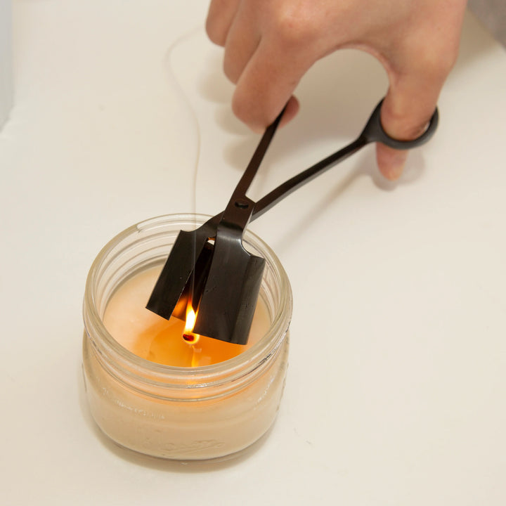 Kikkerland 3-in-1 candle tool with wick trimmer, snuffer, and candle lifter in compact design, ideal for candle maintenance.