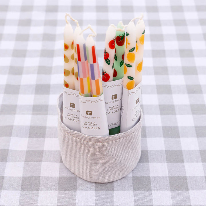 Two multi-colored check taper dinner candles in a pack from Cornucopia Home and Gift, designed for elegant table settings.
