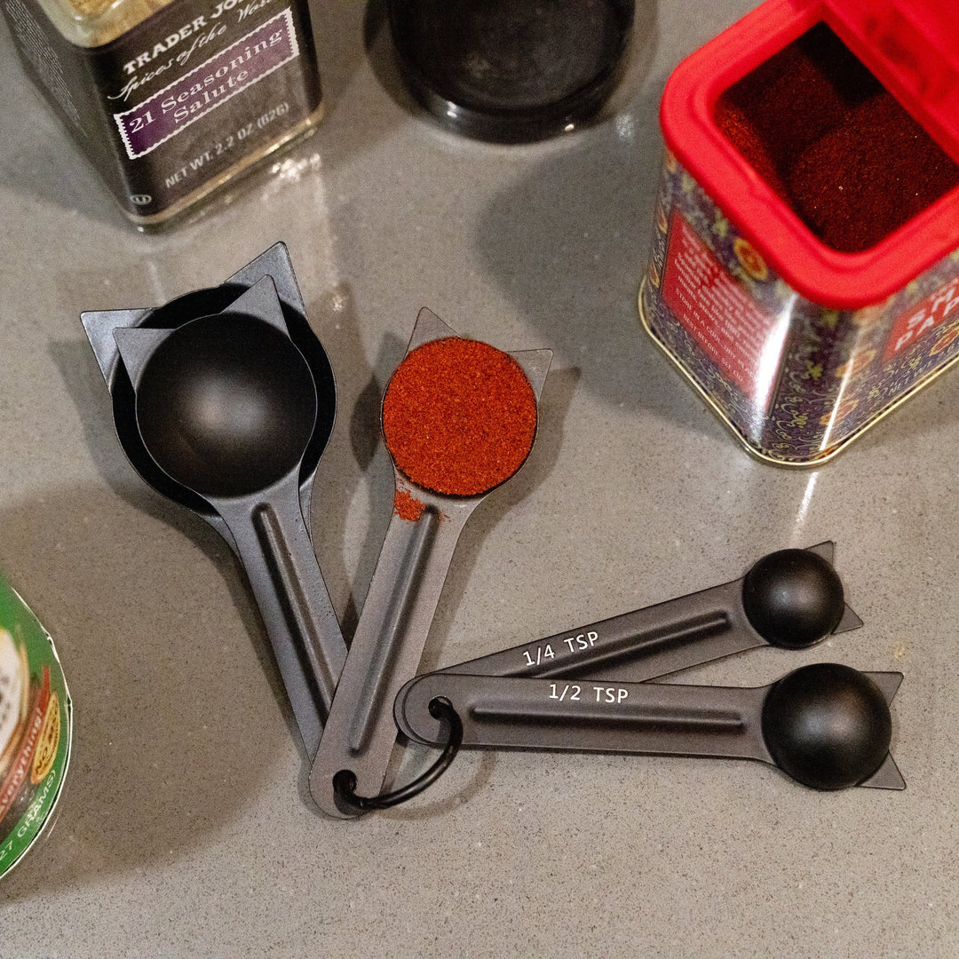 Kikkerland cat-shaped measuring spoons set from Cornucopia Home and Gift, featuring three stainless steel spoons with cat designs.