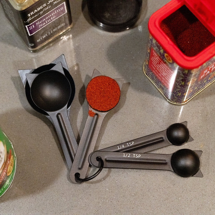 Kikkerland cat-shaped measuring spoons set from Cornucopia Home and Gift, featuring three stainless steel spoons with cat designs.