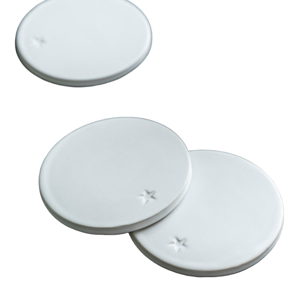 Set of four white round ceramic coasters by Garden Trading, perfect for protecting surfaces with stylish design.