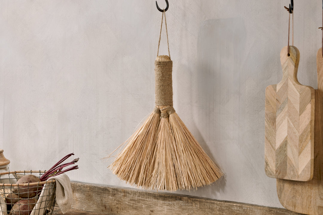Small natural Dulani broom by Nkuku, with wooden handle and straw bristles, perfect for light sweeping tasks.