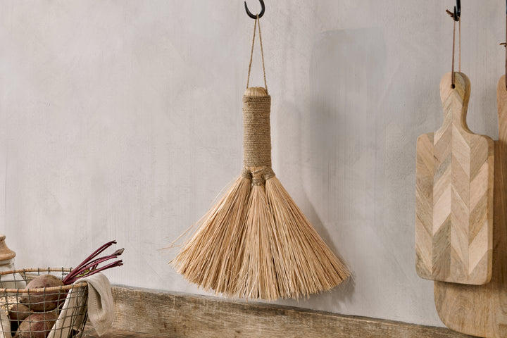 Small natural Dulani broom by Nkuku, with wooden handle and straw bristles, perfect for light sweeping tasks.