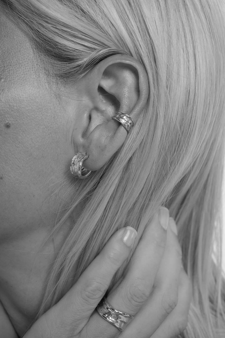 Silver Driftline earrings by Tutti &amp; Co featuring sleek, minimalist design with smooth curves and polished finish.