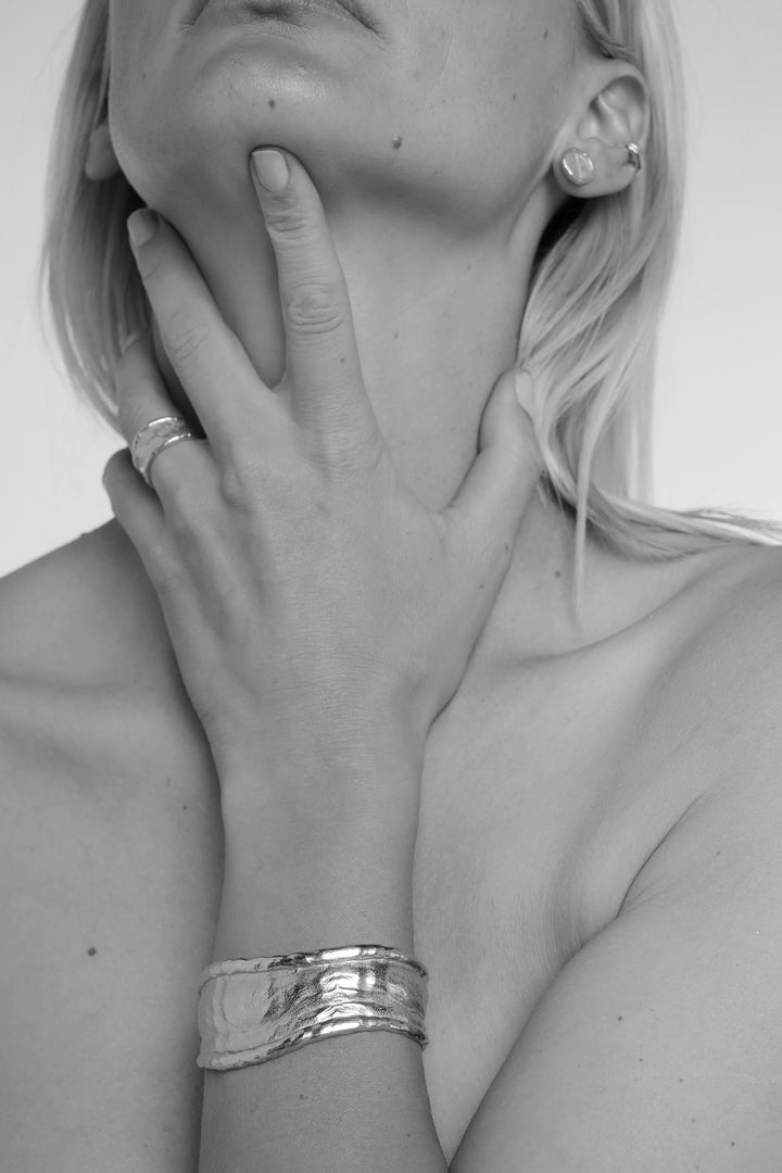 Silver arc cuff bracelet by Tutti &amp; Co, featuring a sleek, minimalist design, displayed on a neutral background.