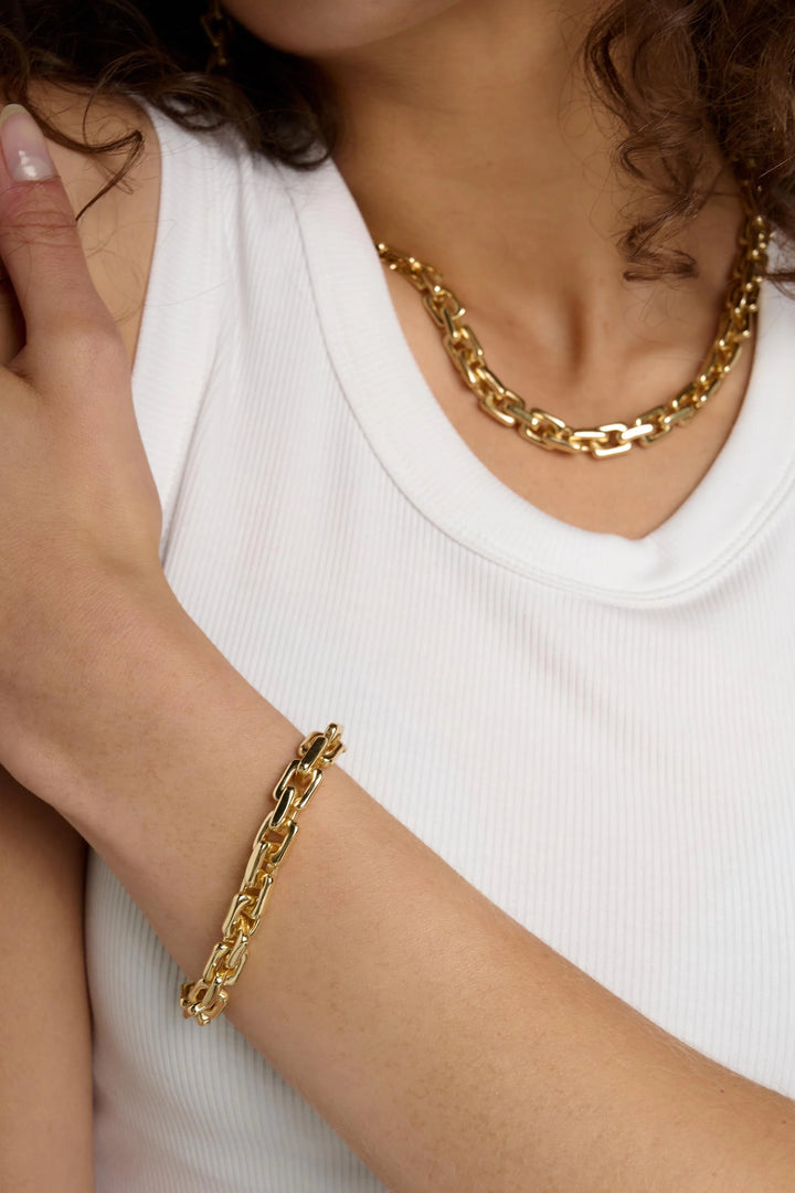Tutti &amp; Co link bracelet with silver-tone chain and intricate link design, displayed on a neutral background.