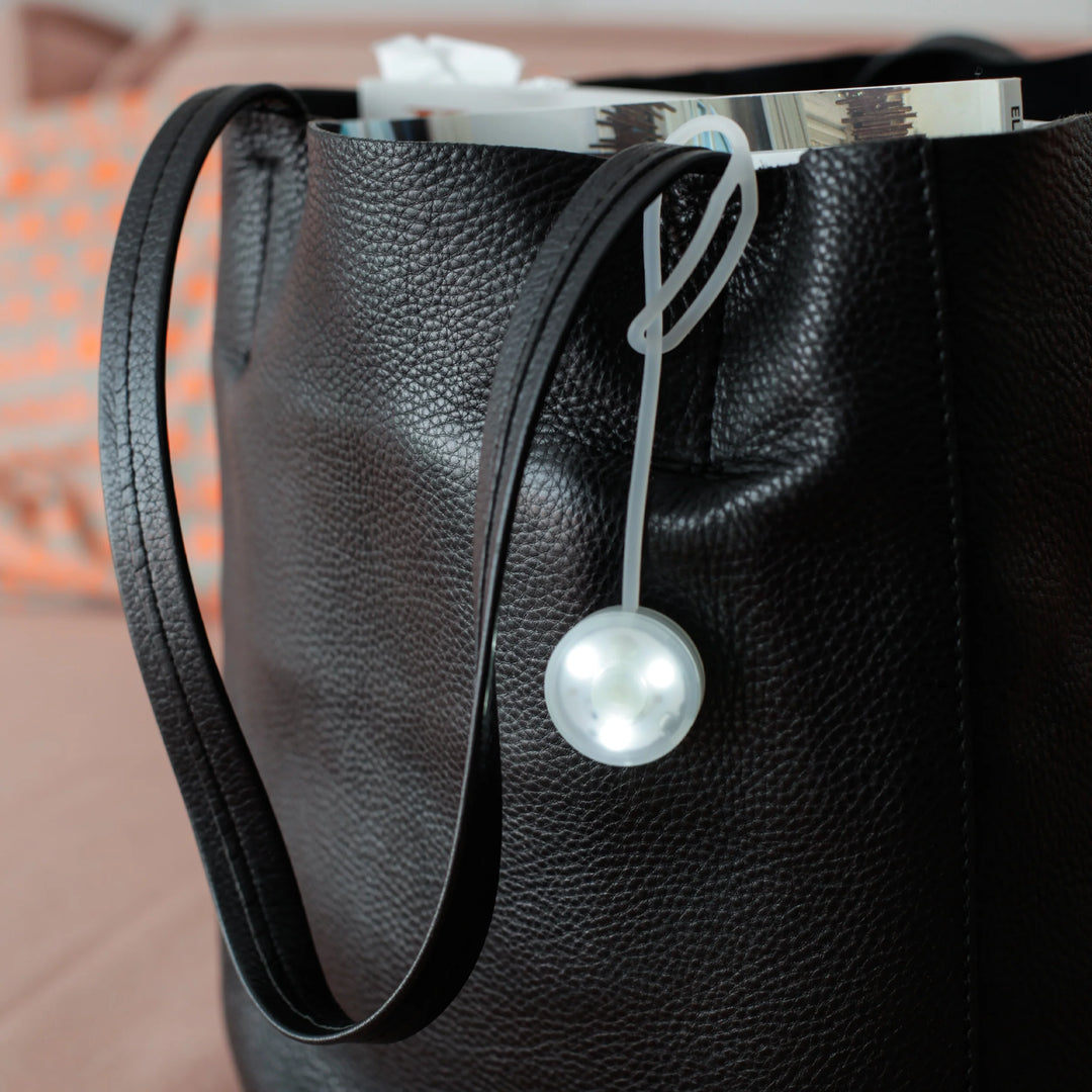 Kikkerland Bag Light from Cornucopia Home and Gift, compact purse-shaped LED light with a clip for portable illumination.