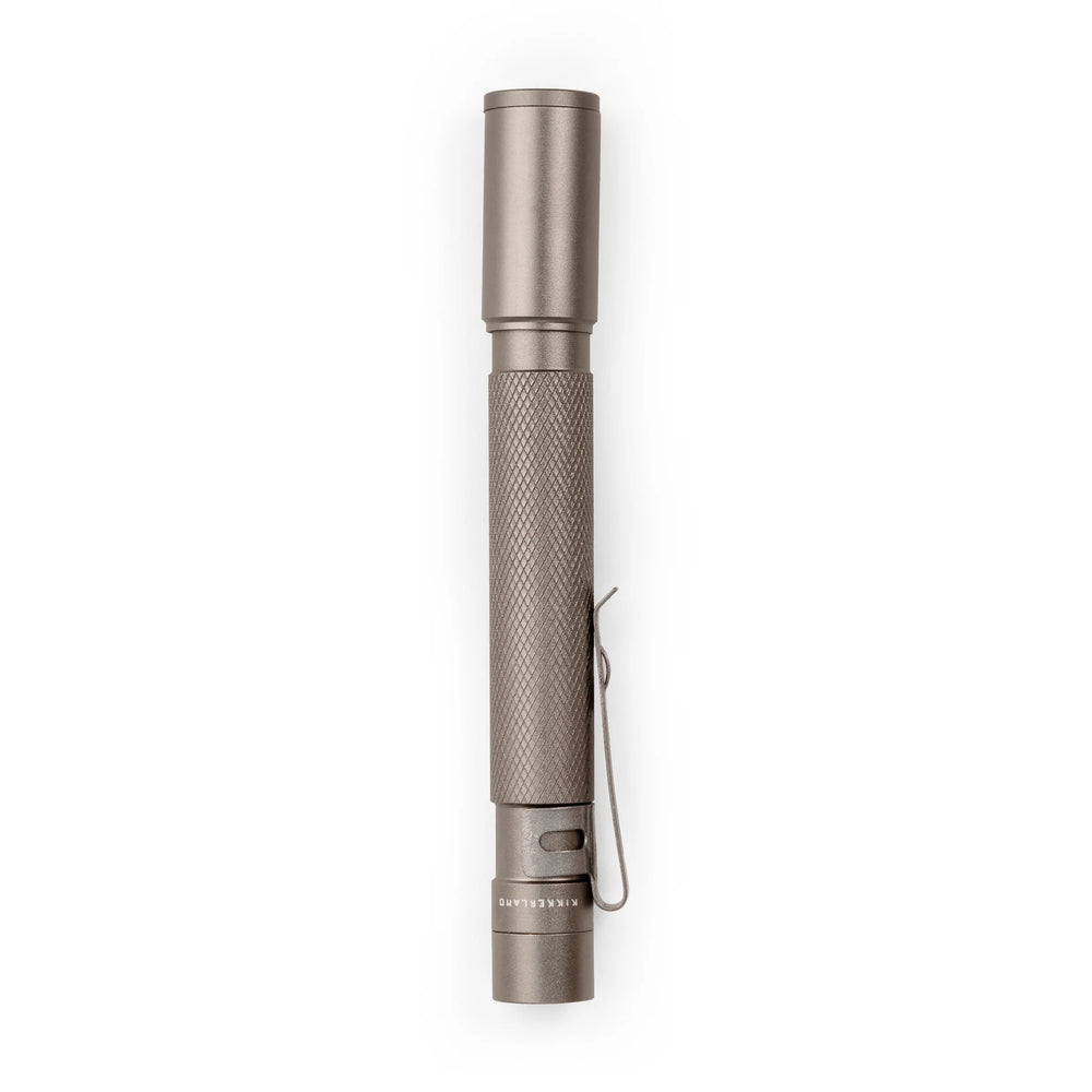 White pocket flashlight by Kikkerland on a plain background, compact and portable LED flashlight for everyday use.