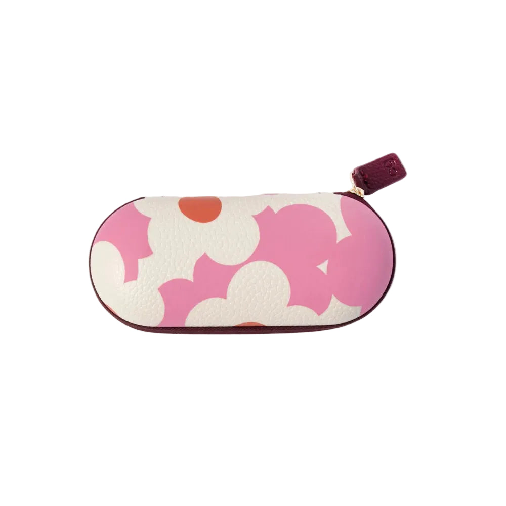 A compact, oval-shaped eyeglasses case featuring a bold pink and white floral pattern with small orange accents, finished with a dark burgundy leather zipper pull.