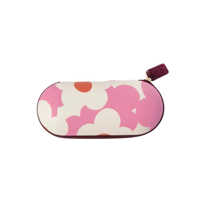 A compact, oval-shaped eyeglasses case featuring a bold pink and white floral pattern with small orange accents, finished with a dark burgundy leather zipper pull.