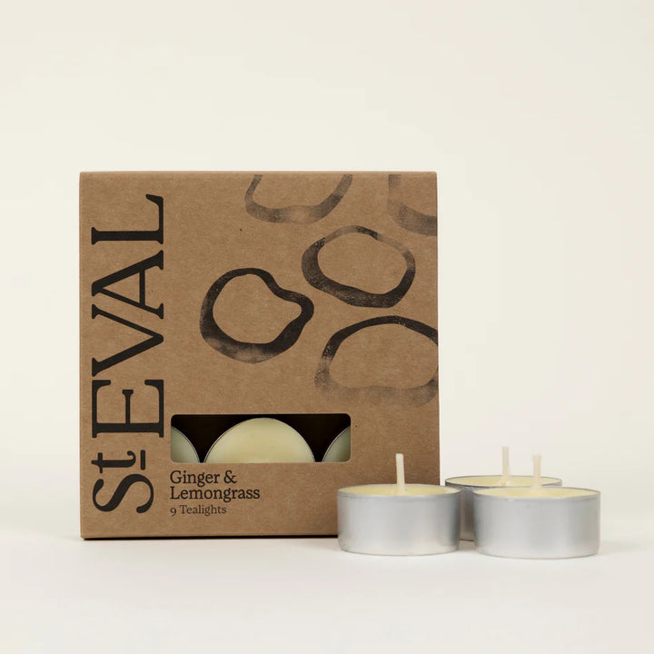 Set of two Ginger and Lemongrass scented tealights by St Eval, with warm glowing candles in clear containers.