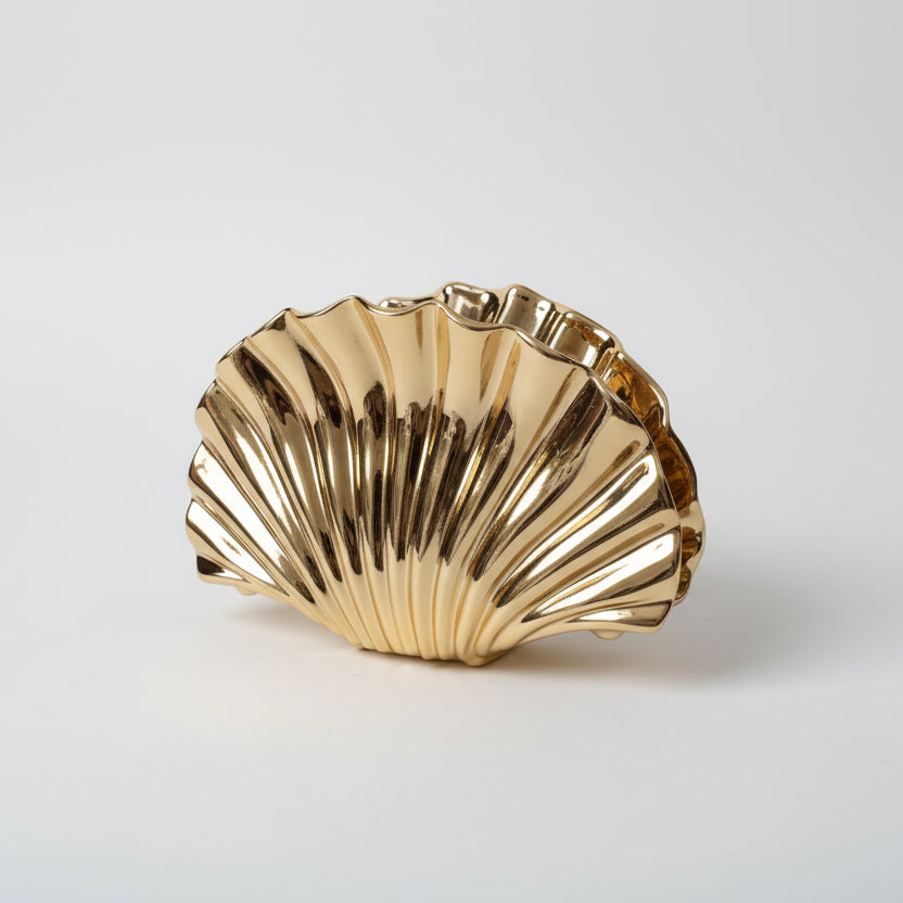 Gold shell-shaped bowl on a white fabric background