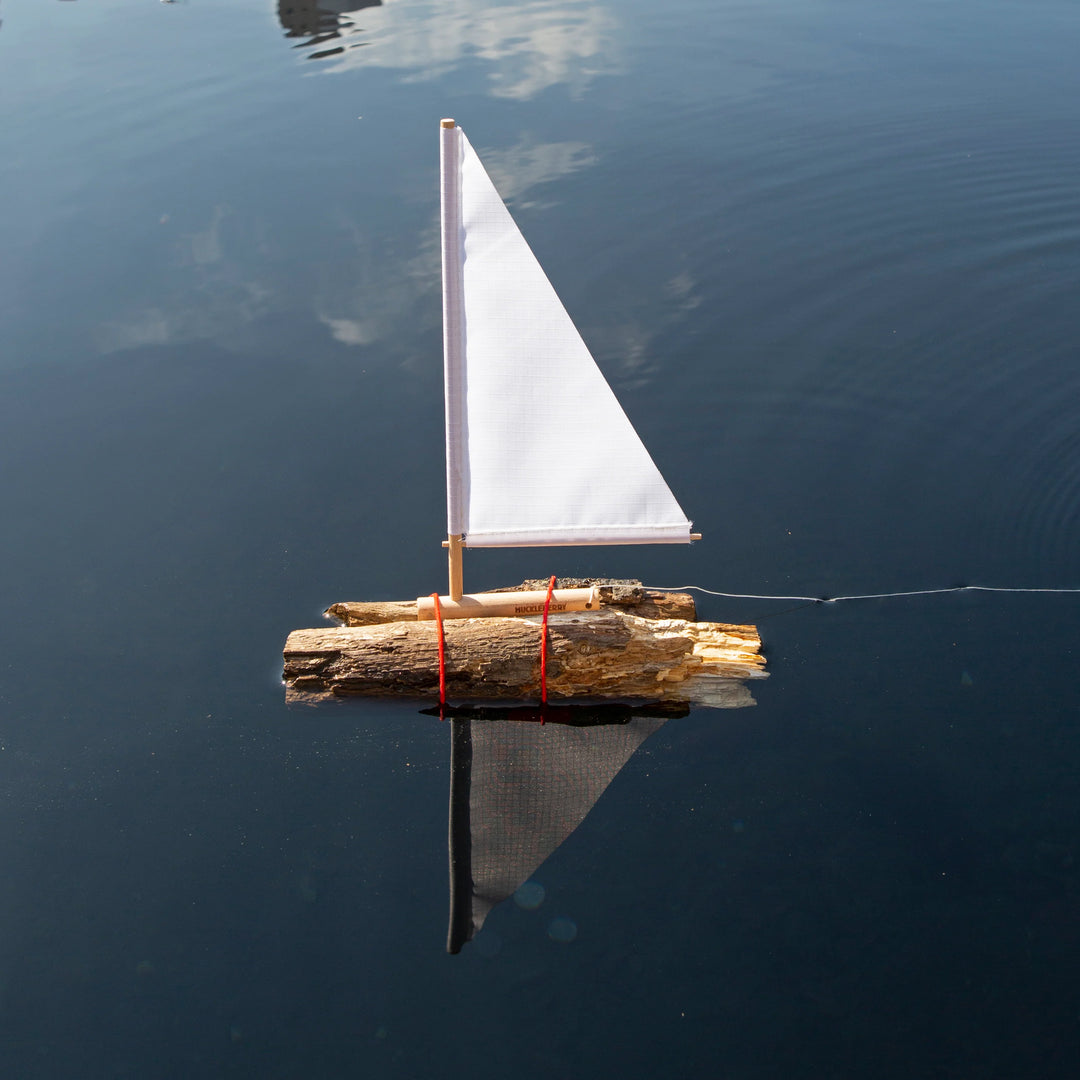 Kikkerland Huckleberry sailboat model by Cornucopia Home and Gift, featuring a detailed miniature sailboat with blue and white sails.