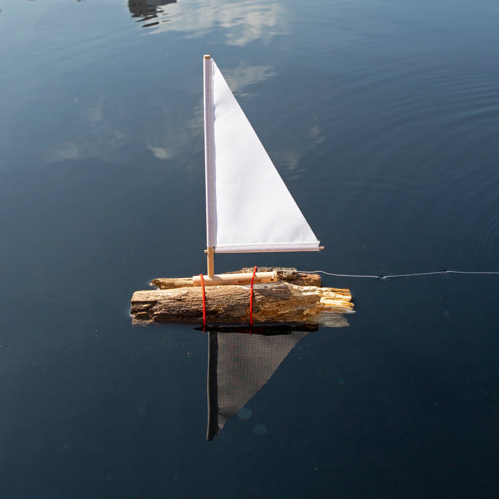 Kikkerland Huckleberry sailboat model by Cornucopia Home and Gift, featuring a detailed miniature sailboat with blue and white sails.