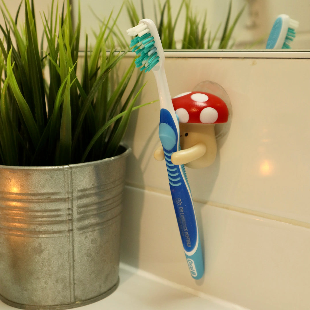 Kikkerland Mushroom Toothbrush Holder from Cornucopia Home and Gift, featuring a whimsical mushroom-shaped design for bathroom storage.