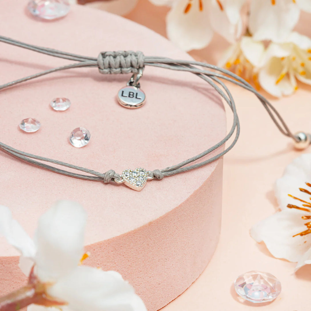 Close-up of a Feeling Blue Sentiment bracelet featuring a heart charm, crafted by Cornucopia Home and Gift, with delicate details.