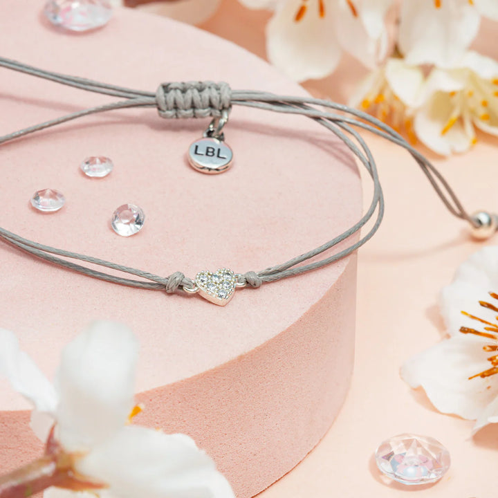 Close-up of a Feeling Blue Sentiment bracelet featuring a heart charm, crafted by Cornucopia Home and Gift, with delicate details.