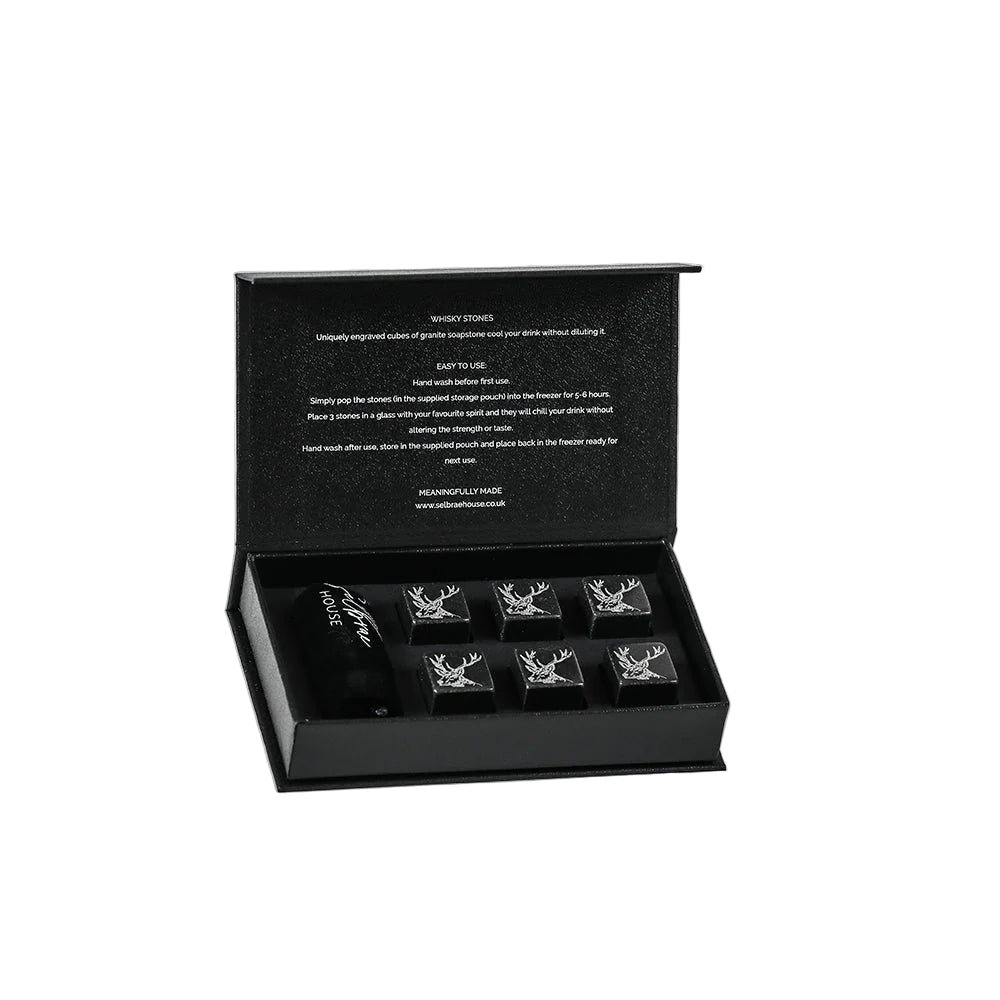 Six Selbrae House whisky stones in a clear glass, with a textured stone appearance, designed to chill drinks without dilution.