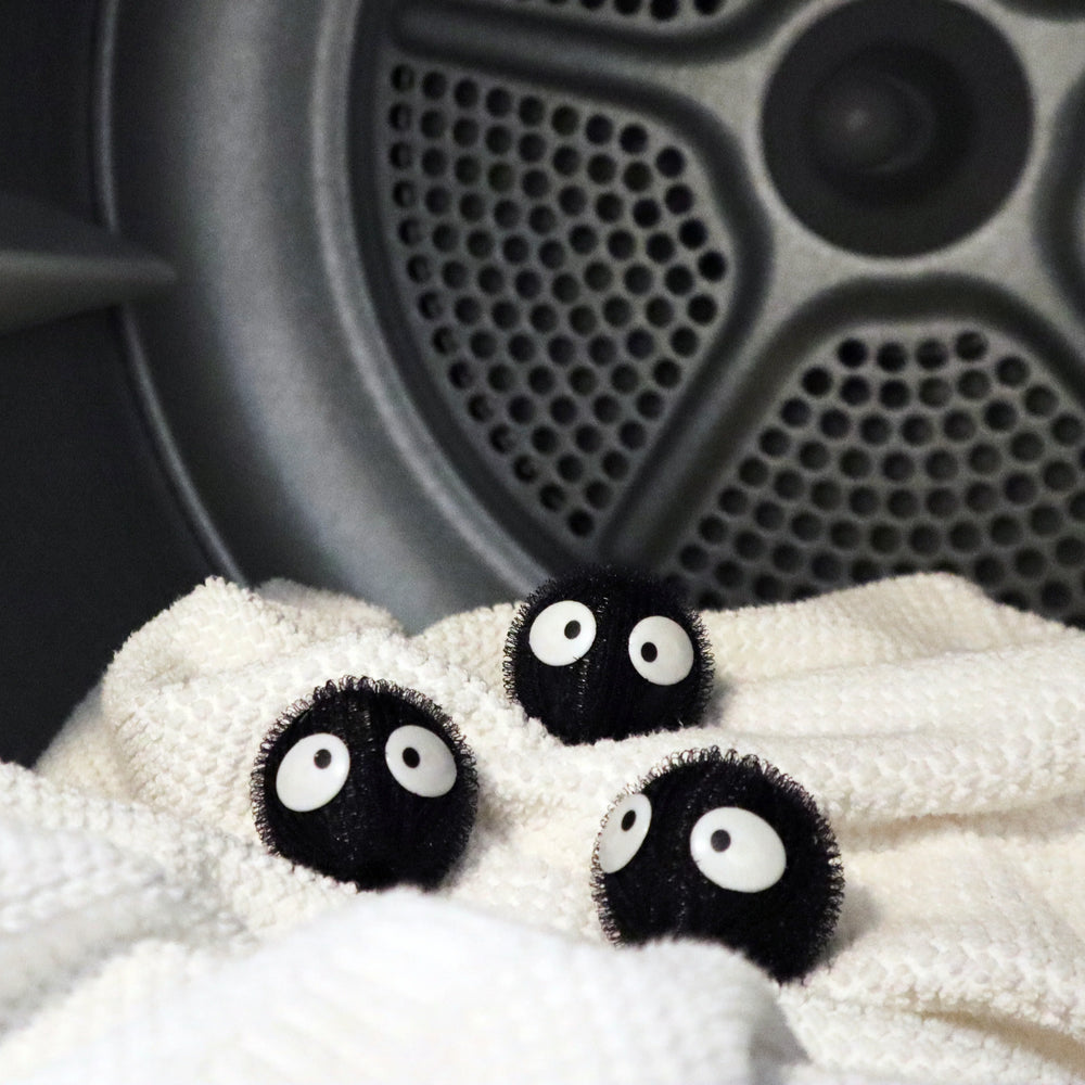 Kikkerland Cornucopia Home Hair Remover Laundry Balls in use, designed to reduce lint and pet hair during laundry.
