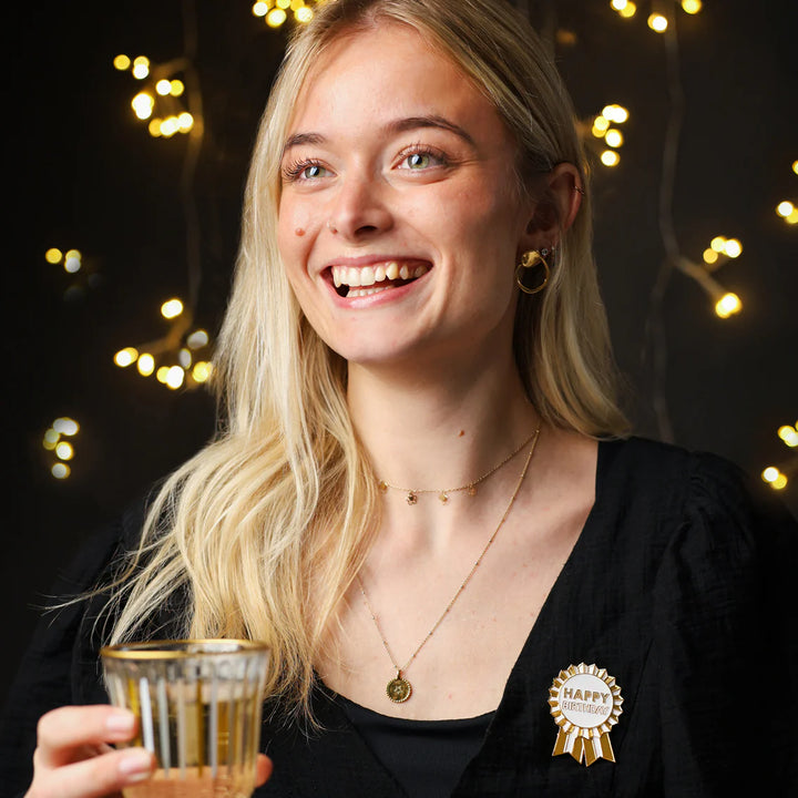 Gold enamel "Happy Birthday" pin badge by Talking Tables with a luxe design from Cornucopia Home and Gift.