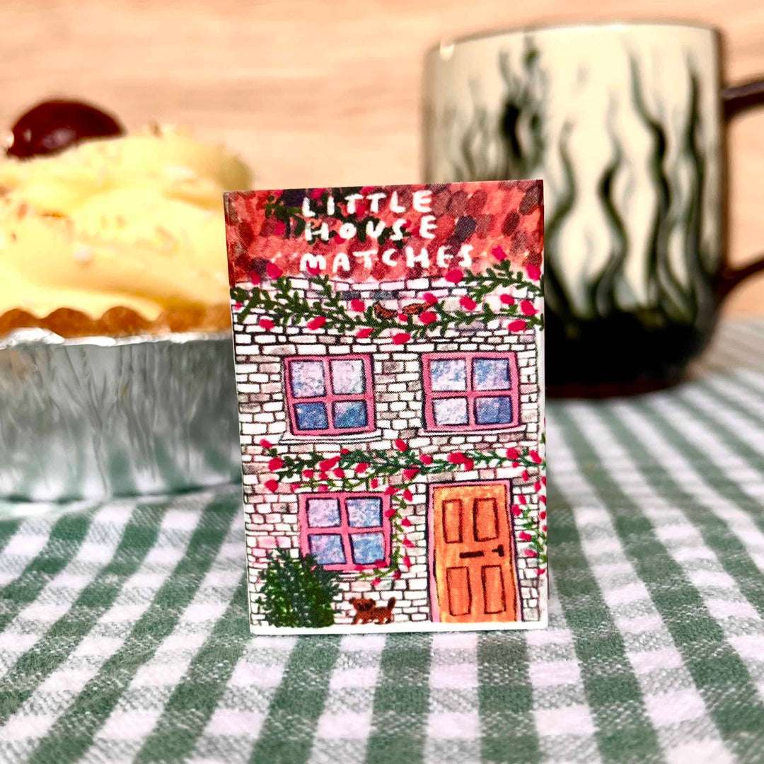 Blue house-shaped matches by Laura Skilbeck for Cornucopia Home, featuring a charming house design and matchstick interior.