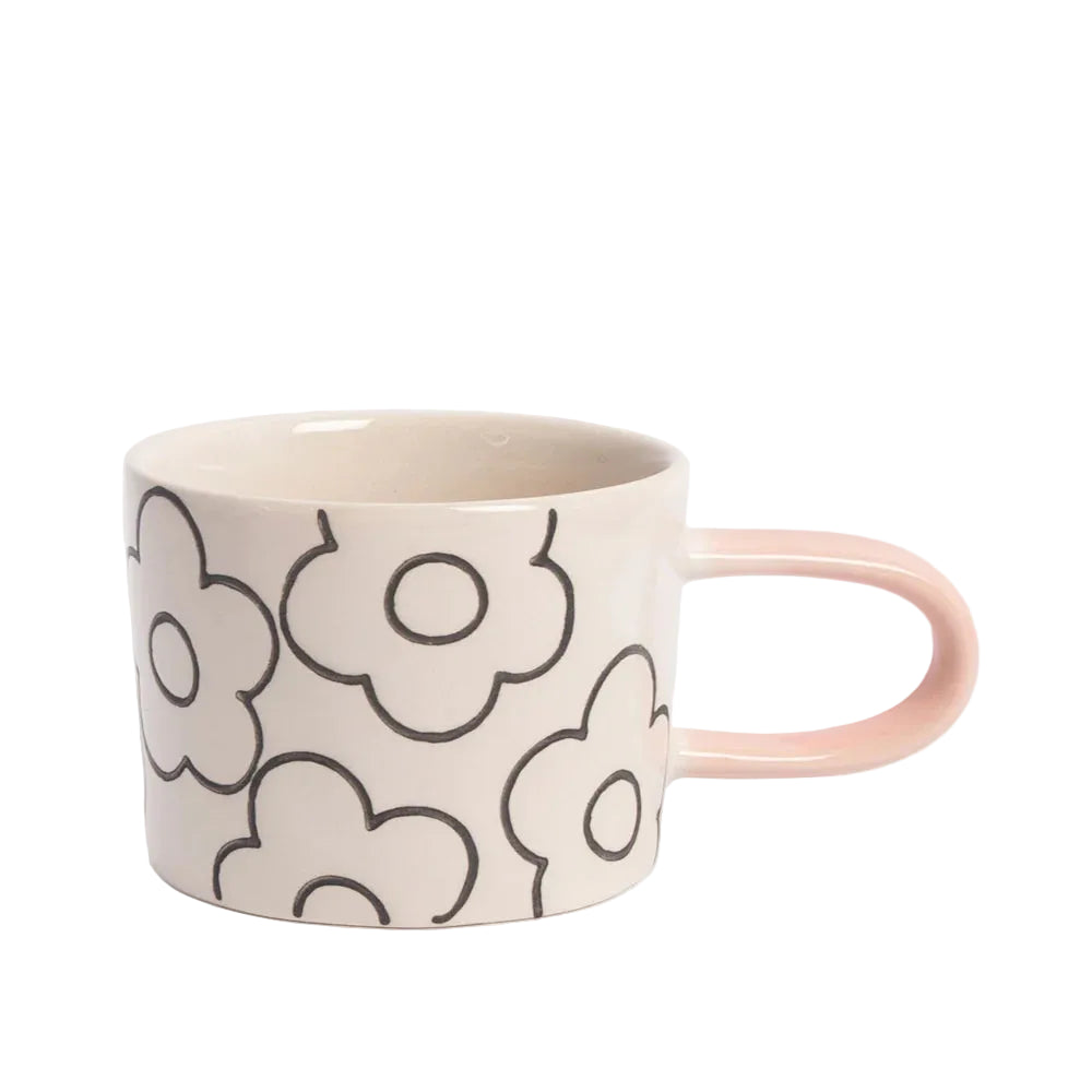 Ceramic mug with floral pattern and pink handle on a white background