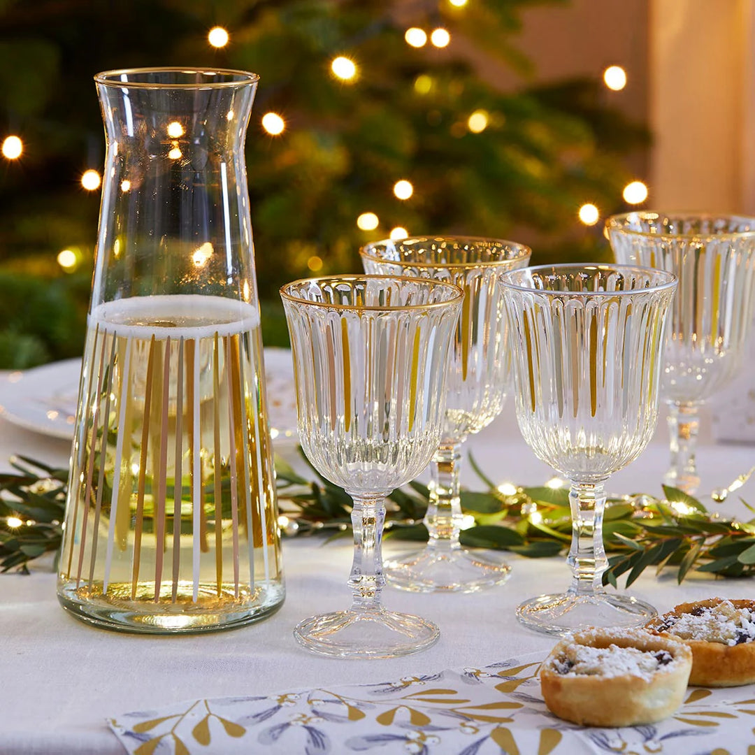 White and gold wine glass from Talking Tables Christmas by Cornucopia Home and Gift, with festive mistletoe design.