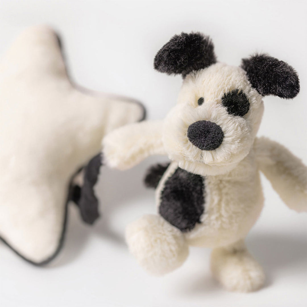 Jellycat Bashful Black &amp; Cream Puppy musical pull toy with soft plush fabric and embroidered features for infants.