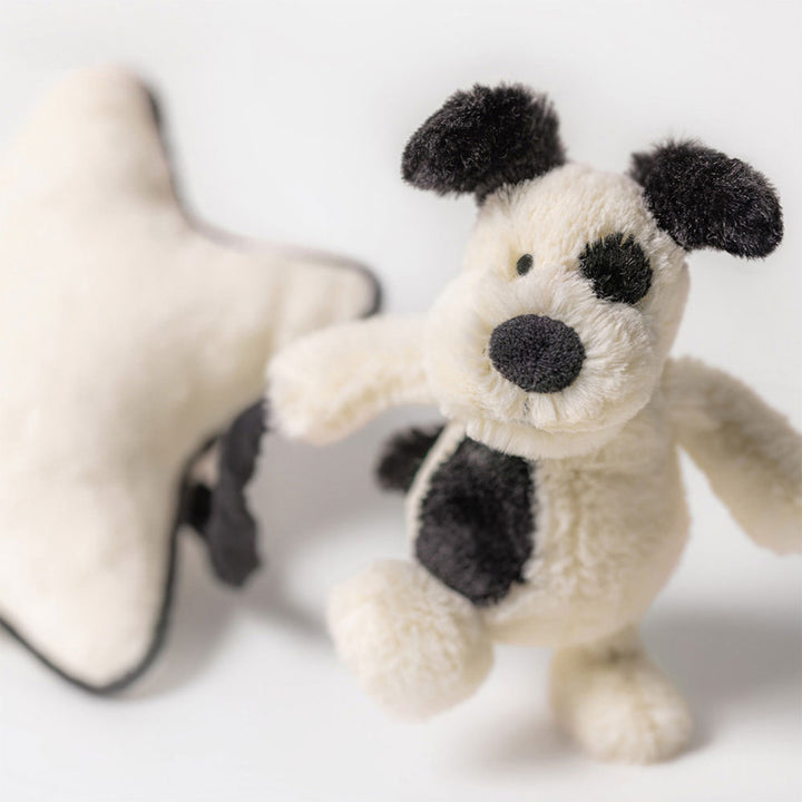 Jellycat Bashful Black &amp; Cream Puppy musical pull toy with soft plush fabric and embroidered features for infants.